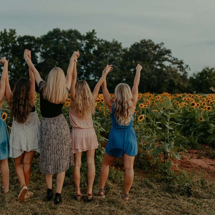 група момичета, стоящи на слънчогледово поле през деня плъзгащ се пъзел онлайн