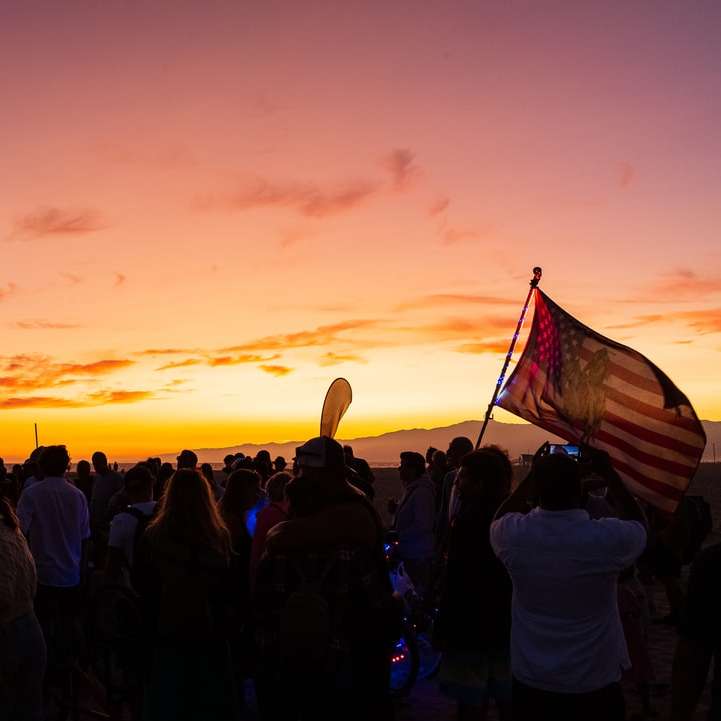 ludzie stojący na polu podczas zachodu słońca puzzle online