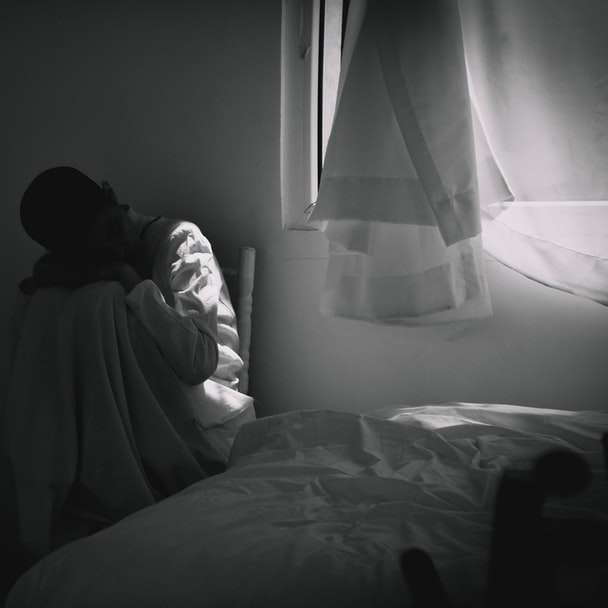 persoon in grijze hoodie zittend op bed schuifpuzzel online