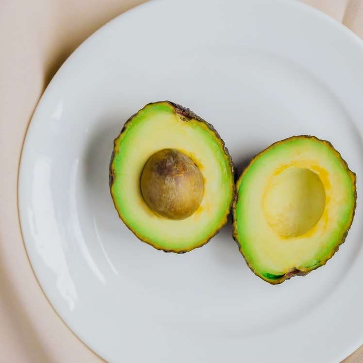 нарязан плод авокадо върху бяла керамична чиния плъзгащ се пъзел онлайн