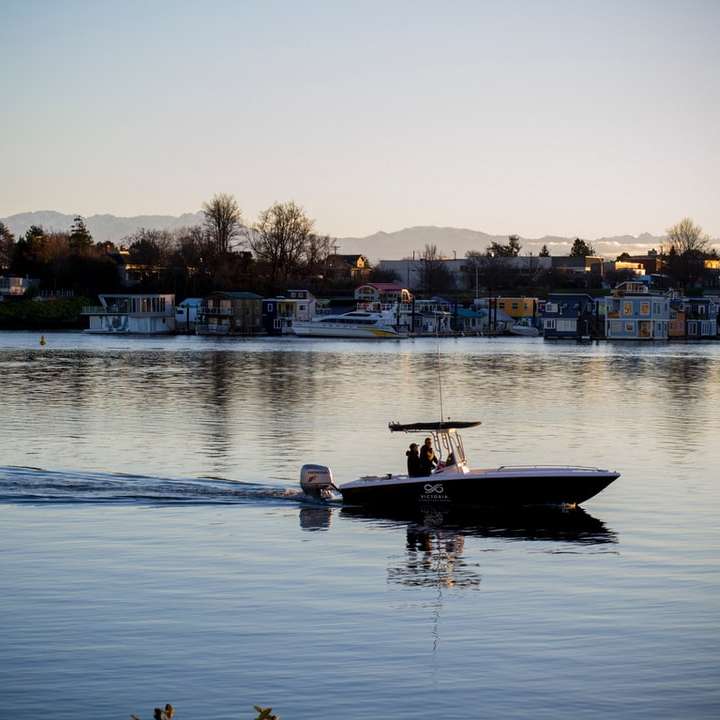 man in wit overhemd rijden op wit en zwart boot op het water online puzzel