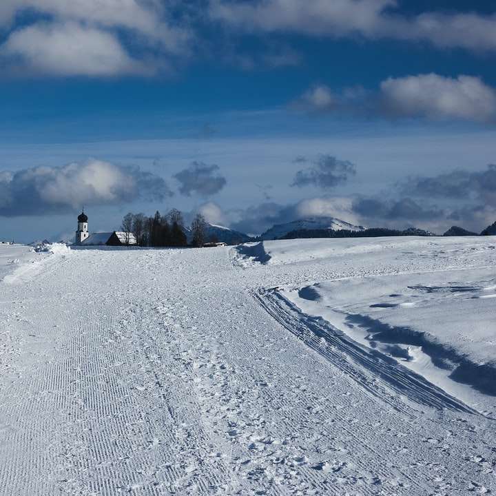 pokryte śniegiem pole pod błękitnym niebem w ciągu dnia puzzle przesuwne online
