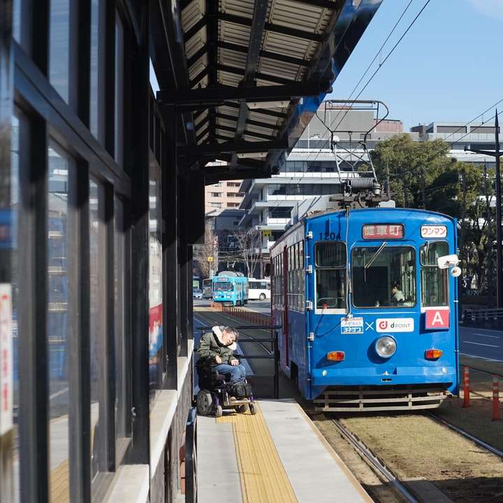 niebieski i biały tramwaj na drodze w ciągu dnia puzzle przesuwne online