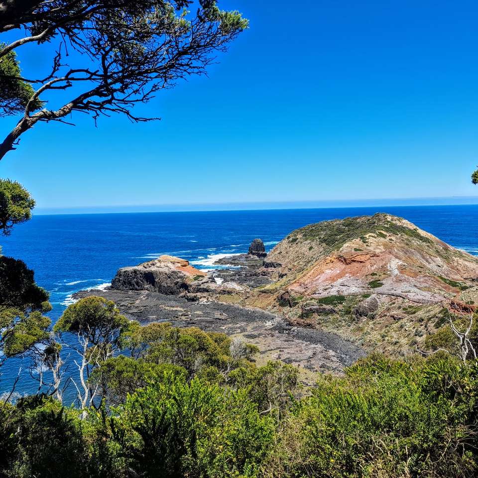 zöld fű a barna szikla kialakulása közelében kék tenger csúszó puzzle online