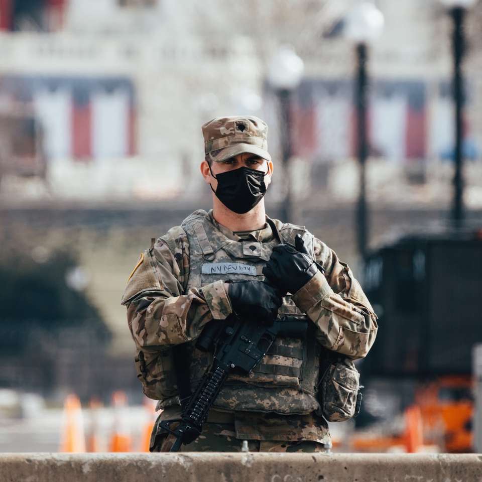 Homme en uniforme de camouflage noir et marron tenant le fusil puzzle en ligne