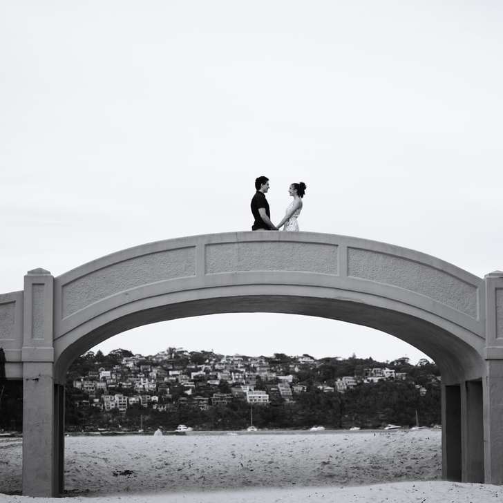 muž stojící na obloukový most během dne online puzzle