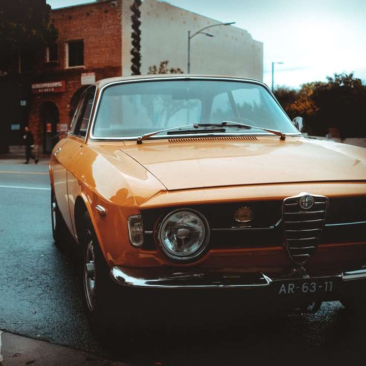 orange och vit klassisk bil på väg under dagtid glidande pussel online