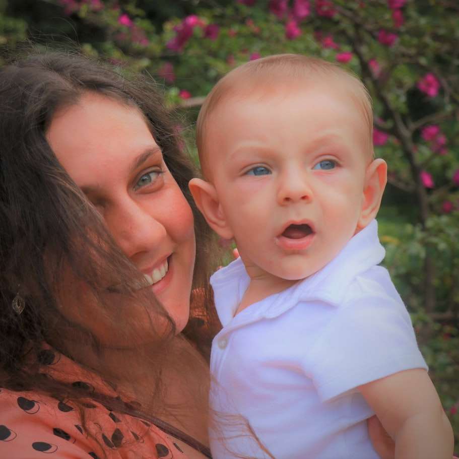 Mujer en camisa naranja y negra con bebé en camisa blanca rompecabezas en línea
