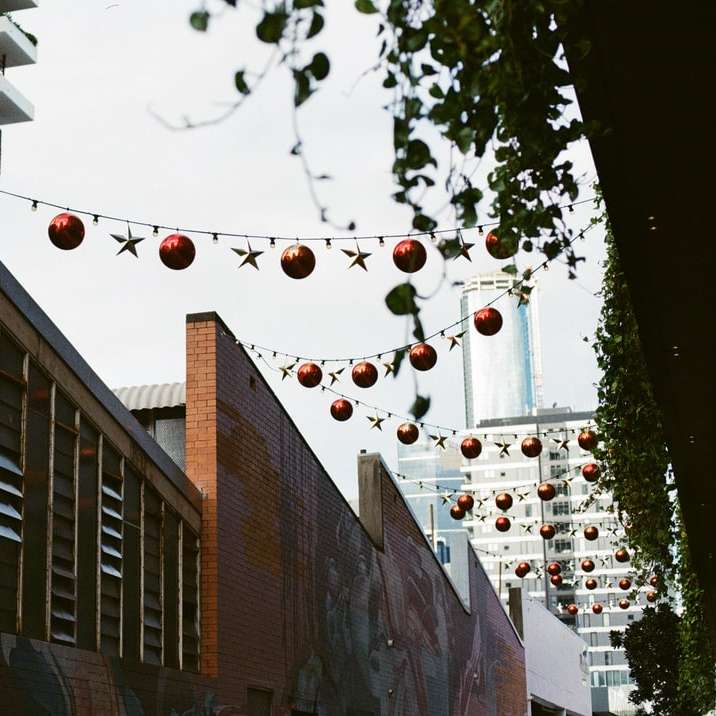 červené a bílé lucerny visící na hnědé cihlové budovy online puzzle