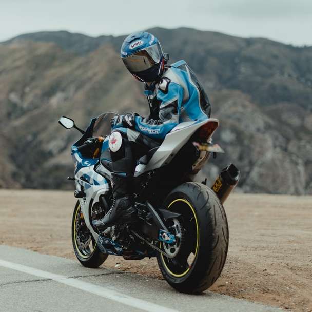 чоловік у синьо-білій куртці їздить на чорному мотоциклі онлайн пазл