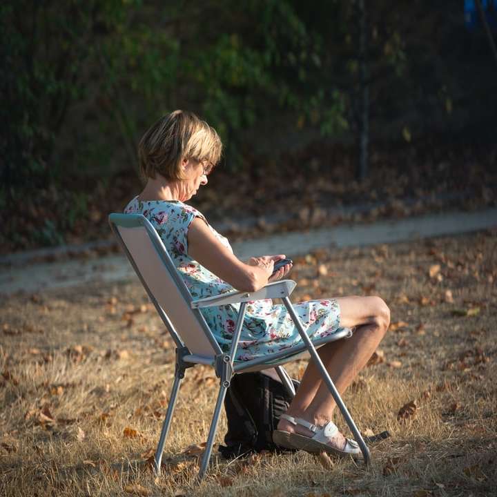 Garçon en débardeur bleu assis sur une chaise pliante puzzle coulissant en ligne