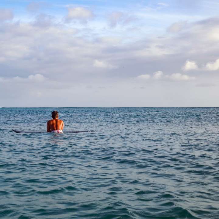 kvinna i blå bikini på vattnet under dagtid glidande pussel online