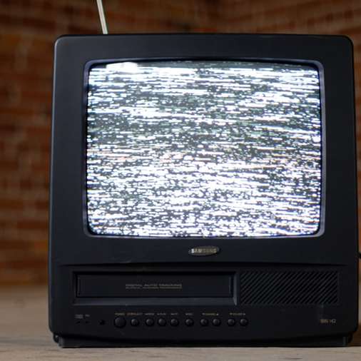 czarny telewizor crt na brązowym drewnianym stole puzzle przesuwne online