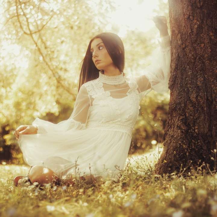 flicka i vit klänning som står på fältet för brunt gräs glidande pussel online