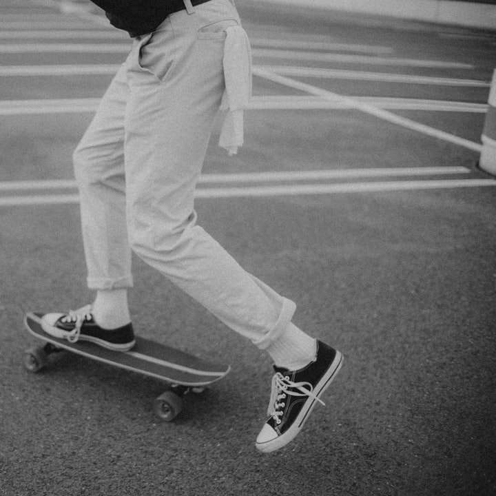 человек в черной толстовке с капюшоном и белых штанах стоит на скейтборде онлайн-пазл