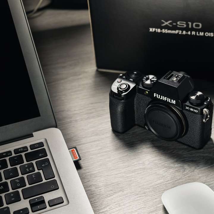 Appareil photo reflex numérique Nikon noir à côté du clavier de l'ordinateur blanc puzzle coulissant en ligne