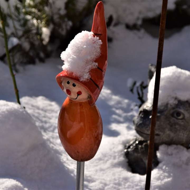 雪に覆われた地面にオレンジ色の鳥の置物 スライディングパズル・オンライン