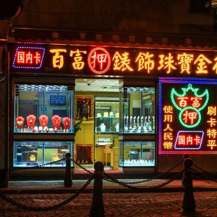 άτομα που περπατούν στο πεζοδρόμιο κοντά στο κατάστημα κατά τη διάρκεια της νύχτας online παζλ