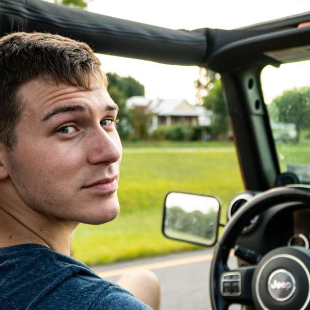 homem de camisa azul com gola redonda, dirigindo carro durante o dia puzzle deslizante online