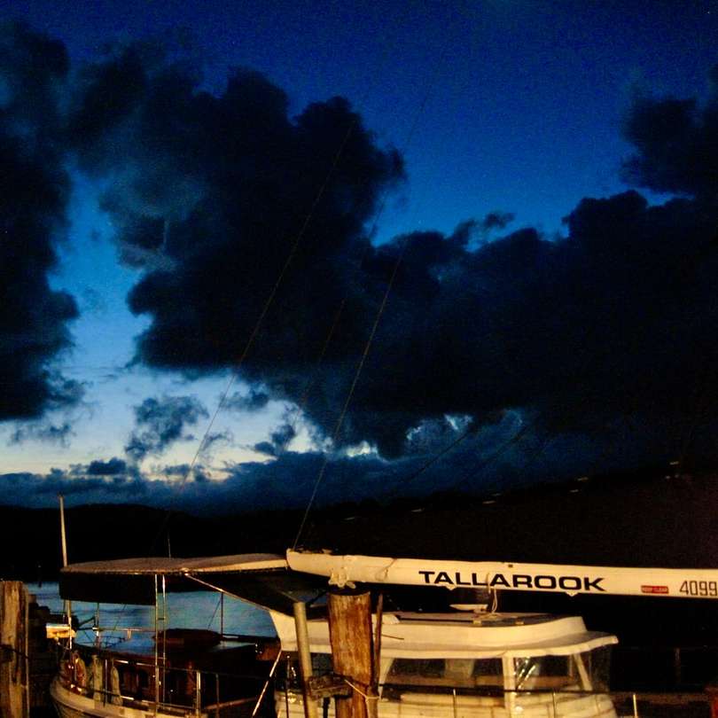 бяла и кафява дървена лодка на док под синьо небе онлайн пъзел