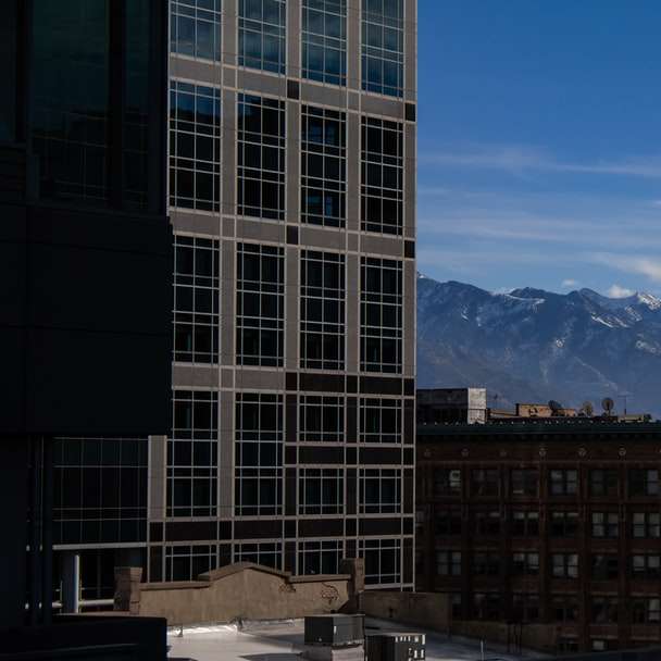 brown concrete building near mountain under blue sky online puzzle