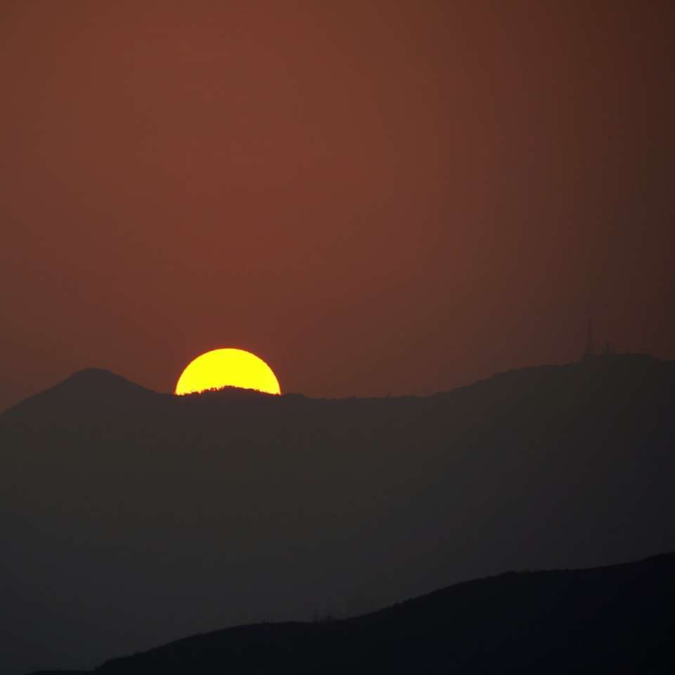 silhueta da montanha durante o pôr do sol puzzle deslizante online
