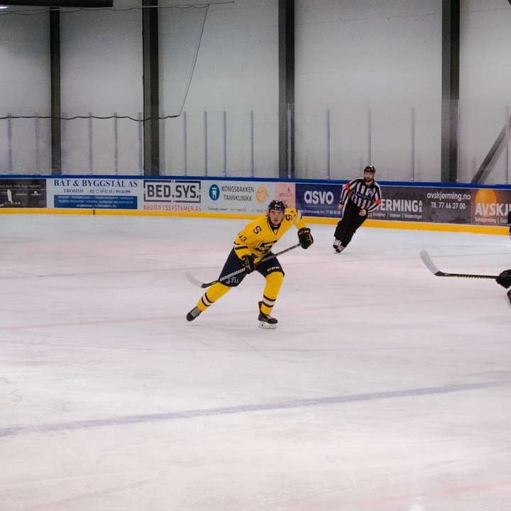 uomo in maglietta gialla che gioca a hockey su ghiaccio puzzle online