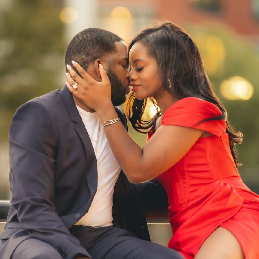 Mann im schwarzen Anzug küsst Frau im roten Kleid Schiebepuzzle online