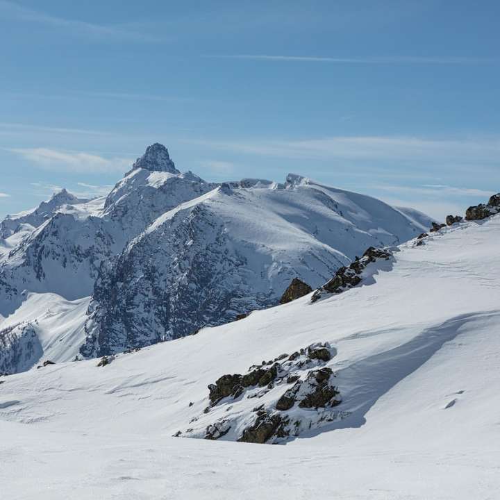 munte acoperit de zăpadă sub cer albastru în timpul zilei puzzle online