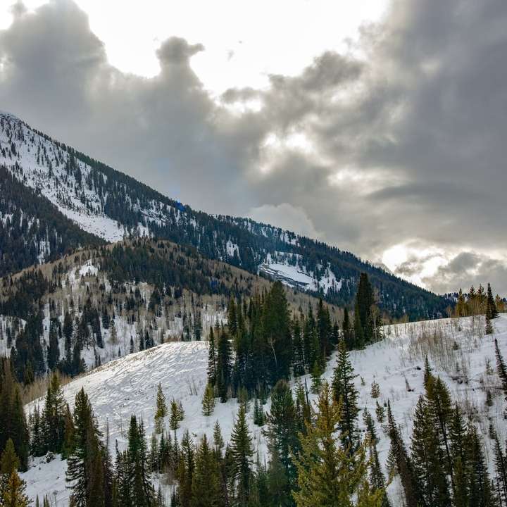 pokryte śniegiem góry pod zachmurzonym niebem w ciągu dnia puzzle przesuwne online