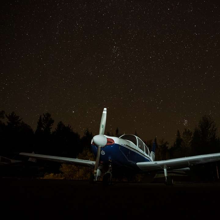 avion blanc au sol pendant la nuit puzzle coulissant en ligne