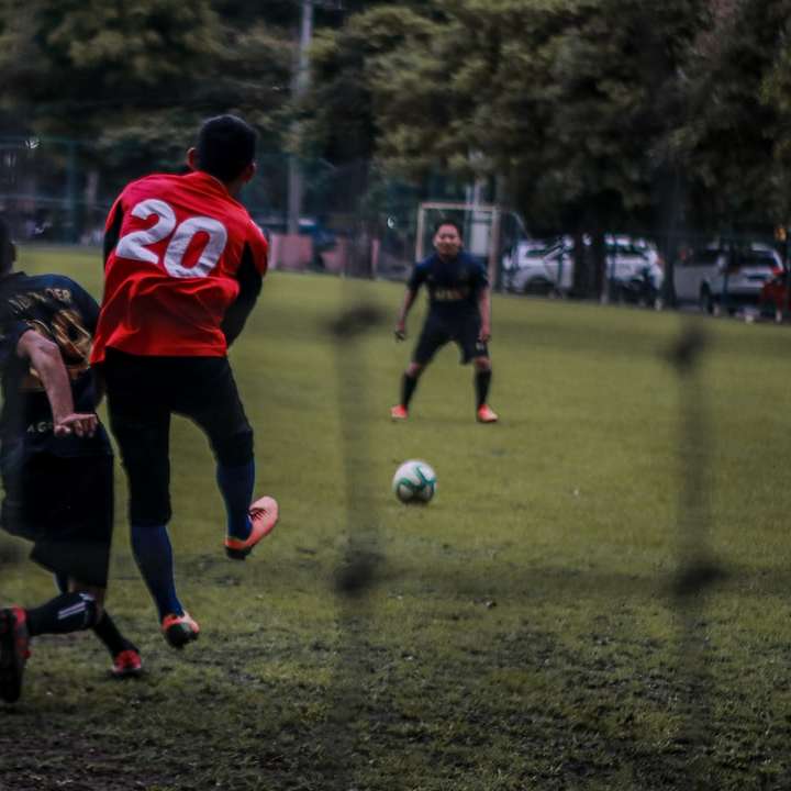 2 niños jugando al fútbol en el campo de hierba verde durante el día rompecabezas en línea
