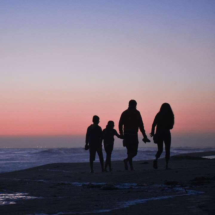 ビーチに立っている3人の男性と女性のシルエット スライディングパズル・オンライン