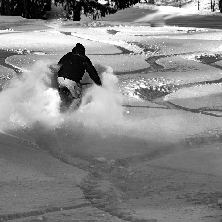 persoon in zwarte jas rijden op witte sneeuw board schuifpuzzel online