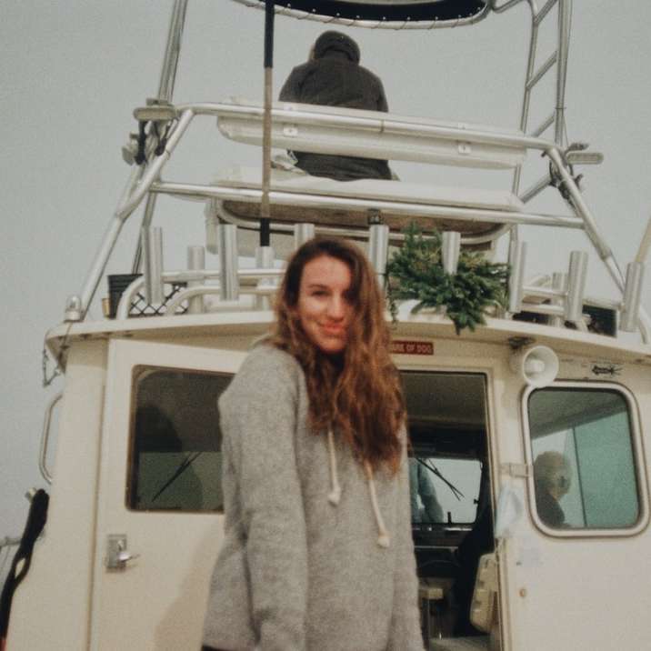 woman in white fur coat standing beside white van online puzzle