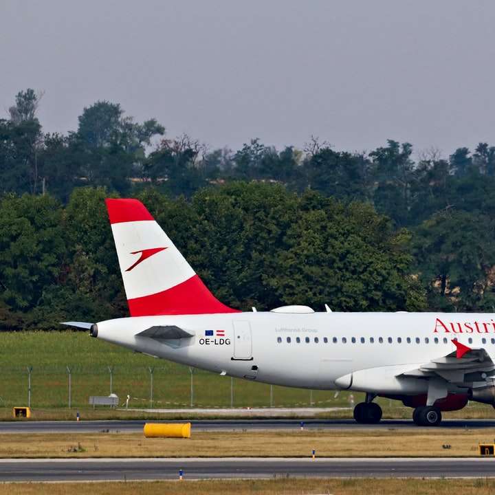 λευκό και κόκκινο επιβατικό αεροπλάνο στο αεροδρόμιο κατά τη διάρκεια της ημέρας συρόμενο παζλ online