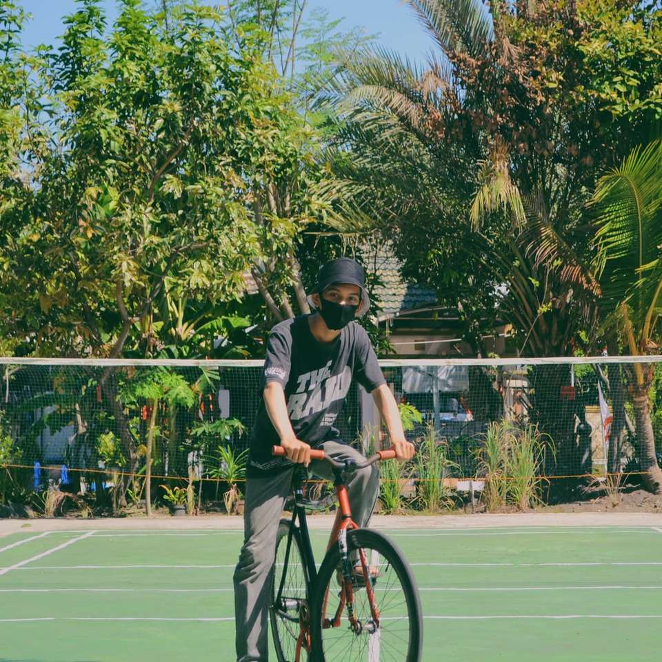 トラックフィールドで自転車に乗る黒いヘルメットの男 オンラインパズル