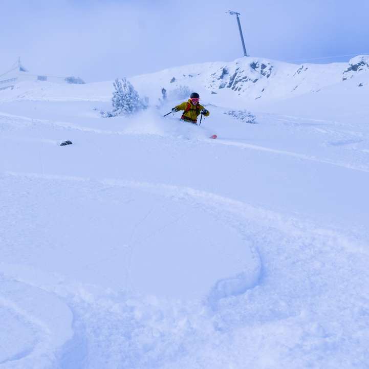 Person in gelber Jacke reitet auf Snowboard Online-Puzzle