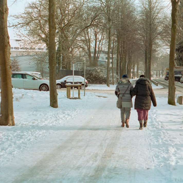 Femme en manteau gris marchant sur un sol couvert de neige puzzle en ligne