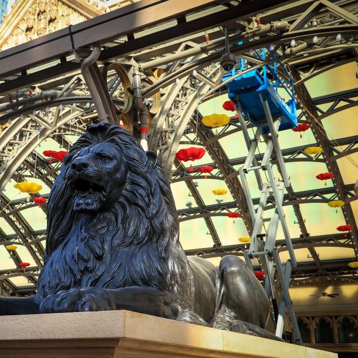 Статуя серого льва возле серого металлического забора онлайн-пазл