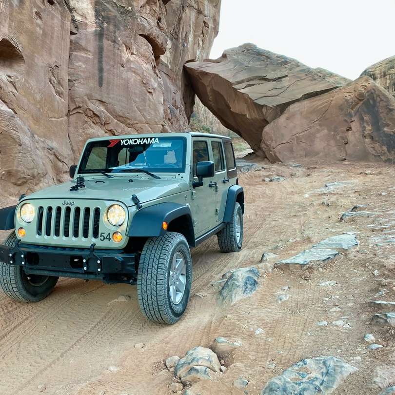niebieski jeep wrangler na kamienistej drodze w ciągu dnia puzzle przesuwne online