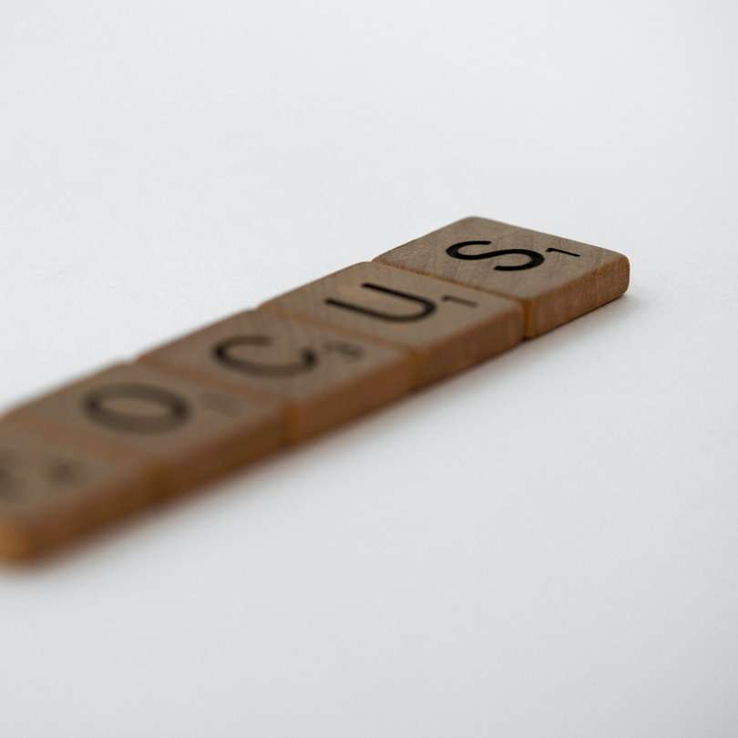 lettera in legno marrone t-sulla superficie bianca puzzle scorrevole online