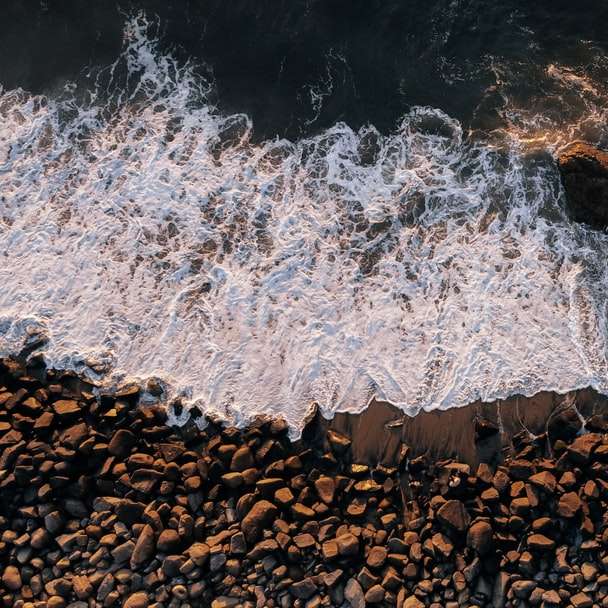 brązowe skały na wodzie w ciągu dnia puzzle online