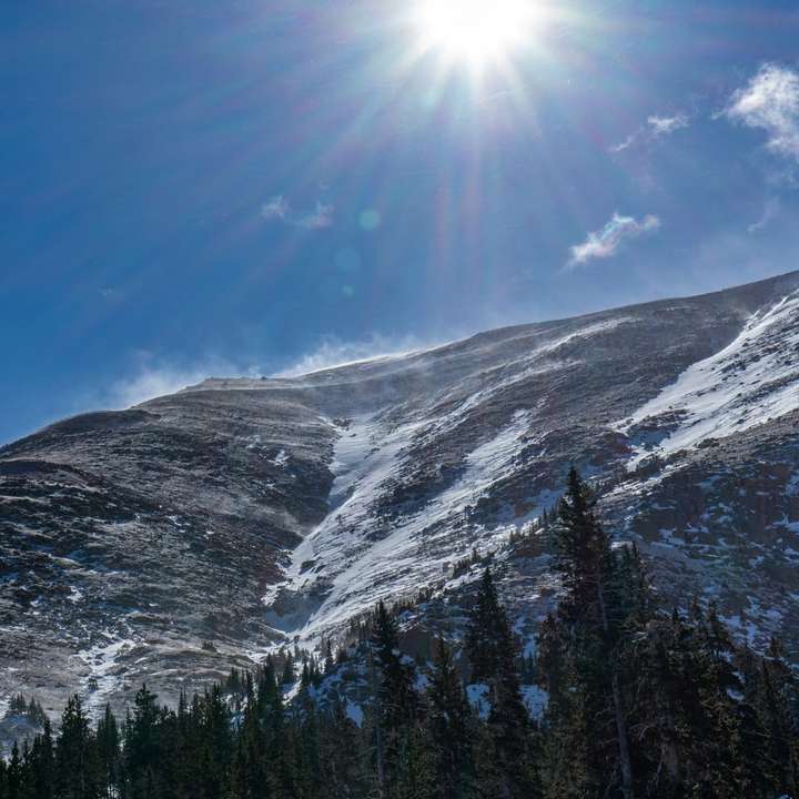 χιονισμένο βουνό κάτω από το γαλάζιο του ουρανού κατά τη διάρκεια της ημέρας συρόμενο παζλ online
