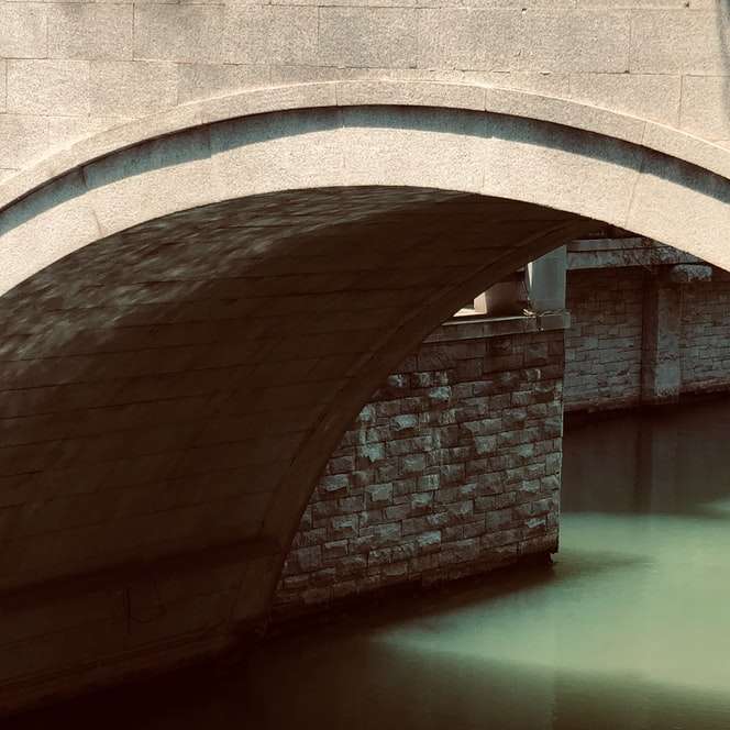 緑の水に架かる茶色のコンクリート橋 オンラインパズル