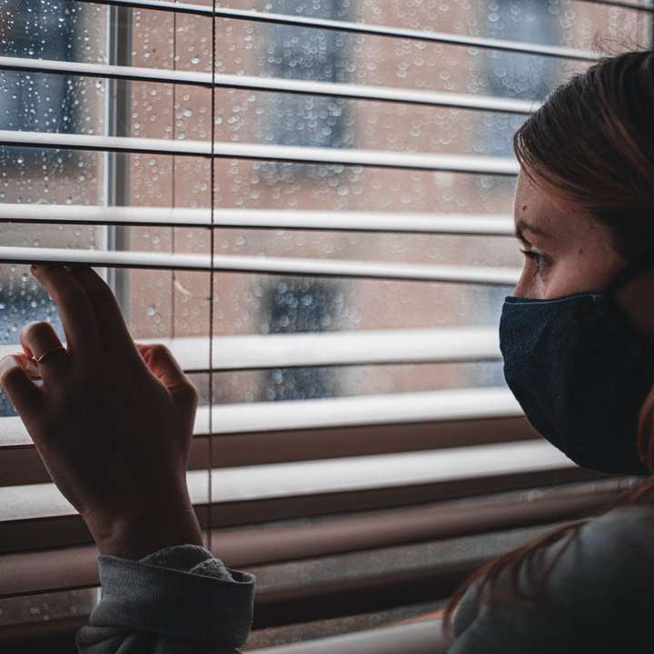 Personne en sweat à capuche noir près de stores blancs puzzle coulissant en ligne