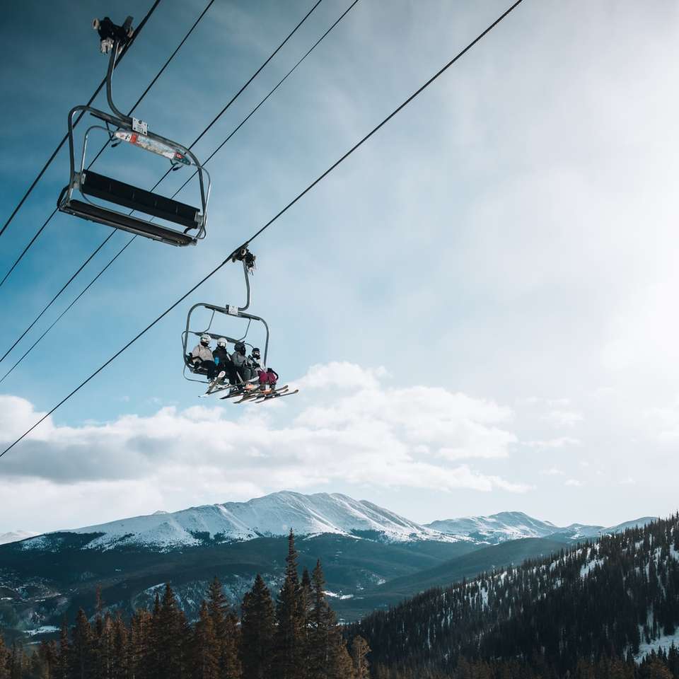 person riding cable car over snow covered mountain sliding puzzle online