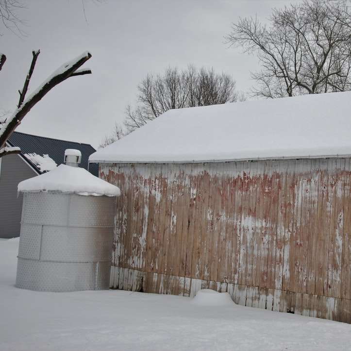 brązowy drewniany dom pokryty śniegiem puzzle przesuwne online