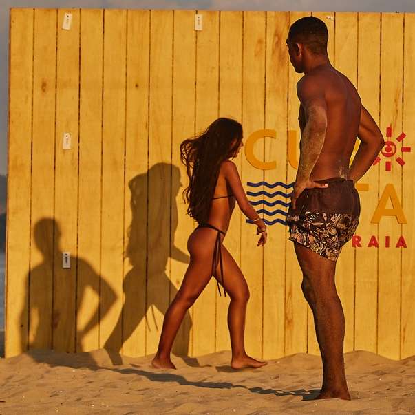 mężczyzna i kobieta stojąc na plaży w ciągu dnia puzzle przesuwne online