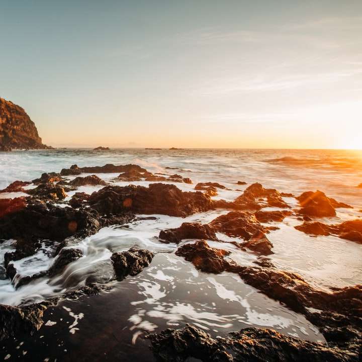 Orilla rocosa con olas de agua durante el día. puzzle deslizante online